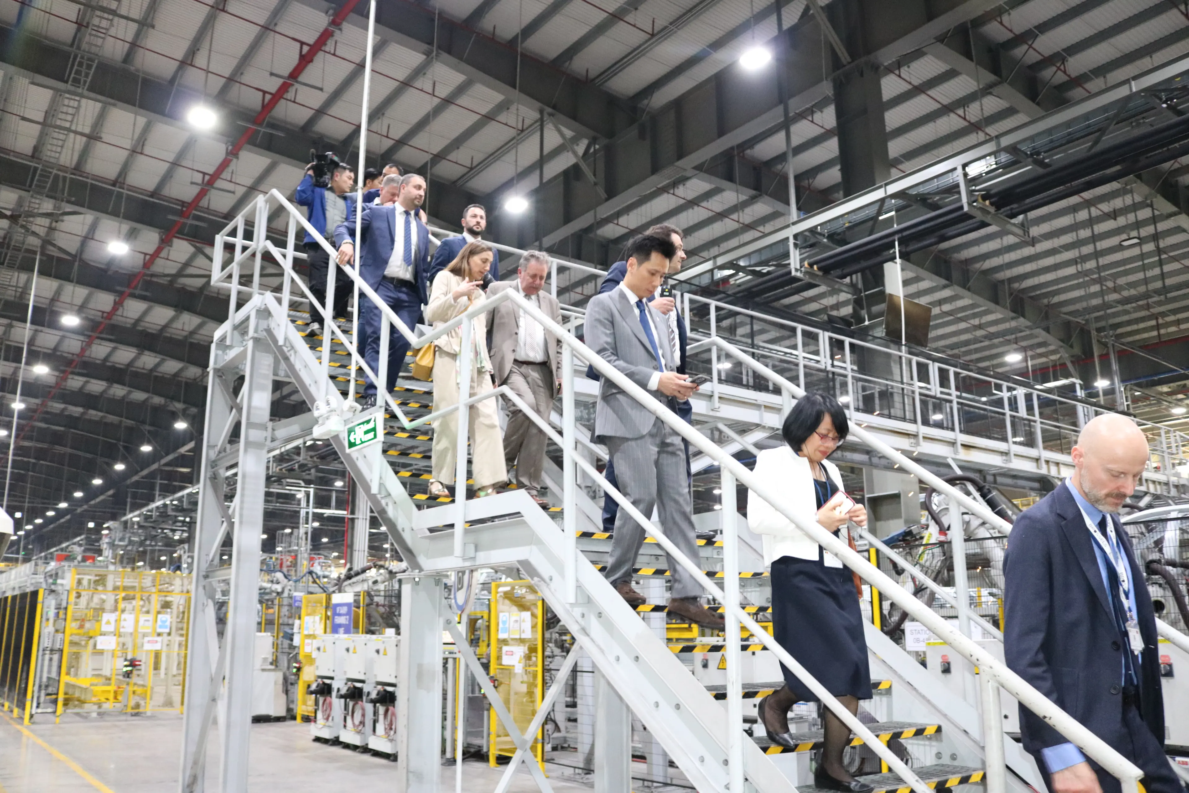 Een groep Vietnamezen en Belgen op een trap in de fabriek
