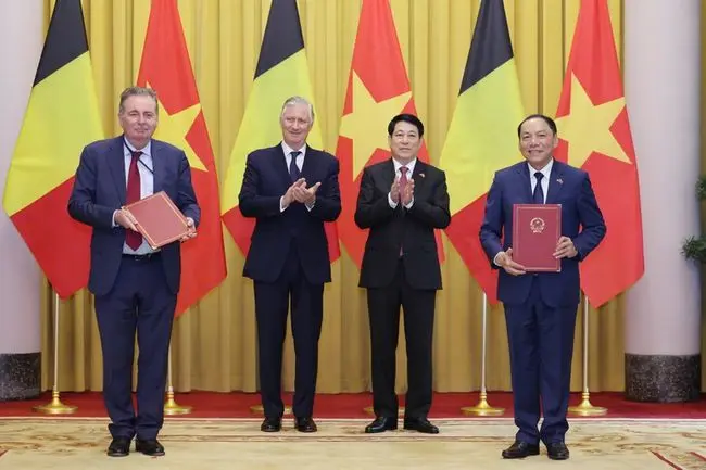 Koning Filip, Lương Cường, President van Vietnam, Rudi Vervoort, Minister-President van het BHG en Nguyễn Văn Hùng, Vietnamees Minister van Cultuur, poseren voor de Belgische en Vietnamese vlaggen.