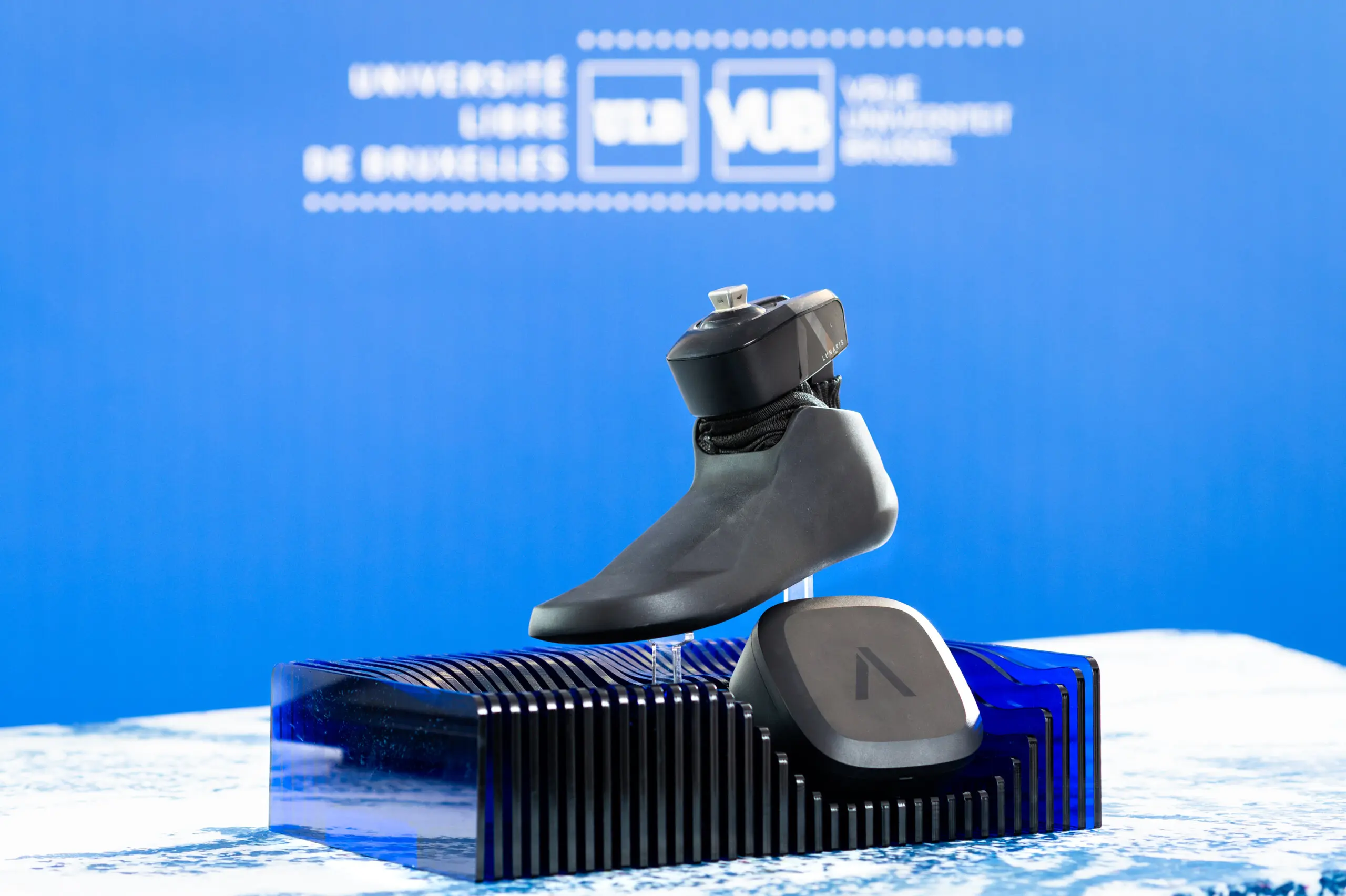 Un pied prothétique présenté sur un socle bleu