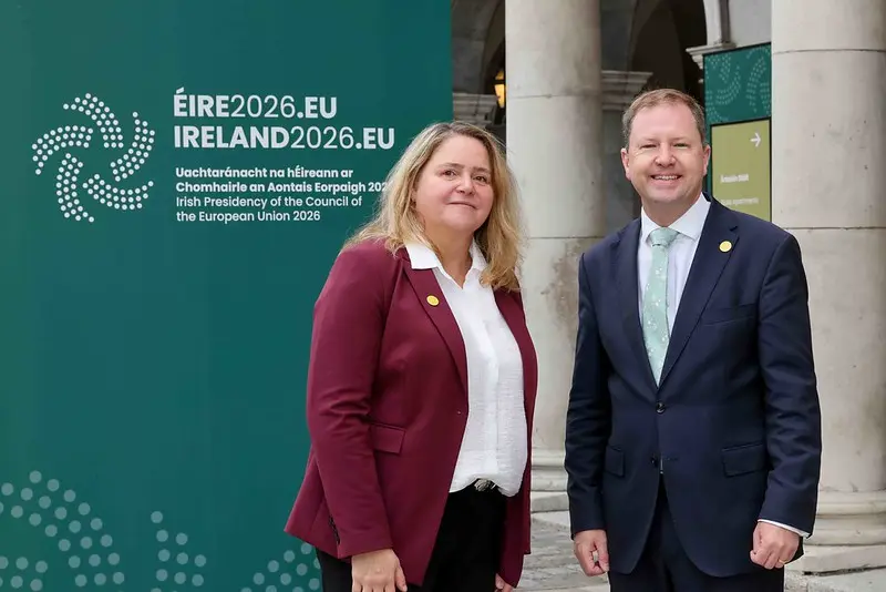 The two participants standing in front of an Irish Presidency of the Council of the European Union panel